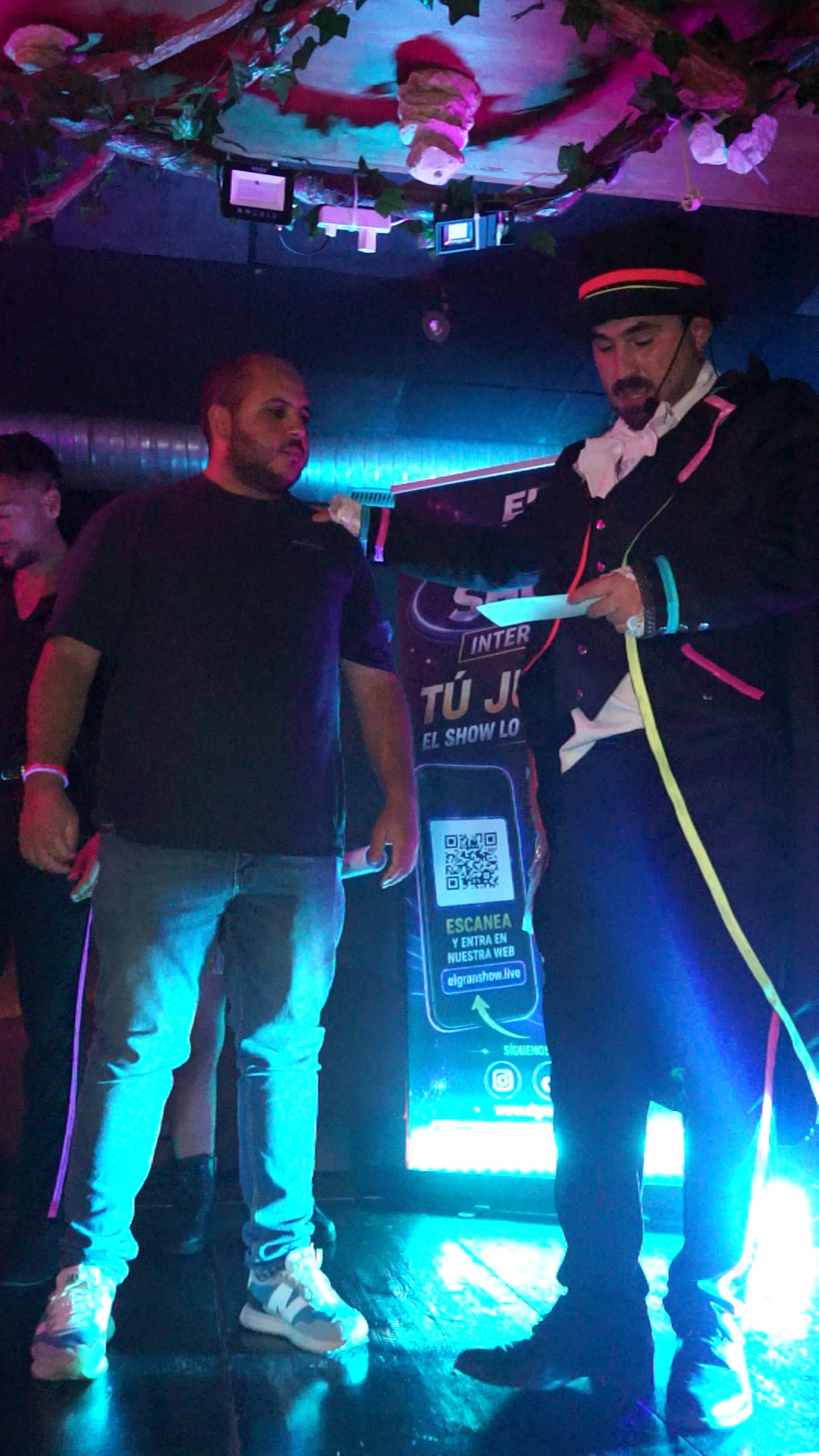 El presentador junto a un participante en el escenario de El Gran Show